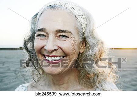 Stock Photo - Portrait of smiling older Caucasian woman at beach. Fotosearch