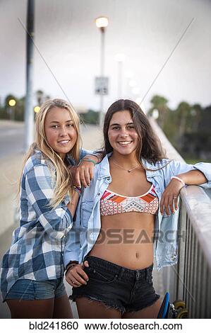 Portrait of smiling teenage girls leaning on railing View Large Photo Image Stock Image - Portrait of smiling teenage girls leaning on railing. Fotosearch