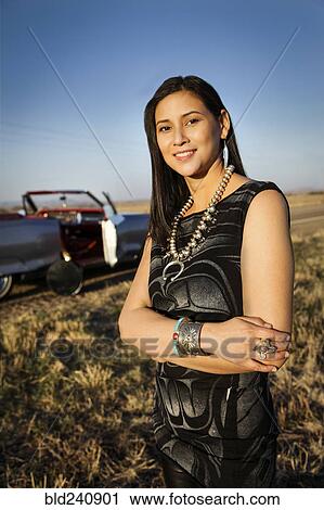 Portrait of smiling woman standing in grass near car View Large Photo Image Stock Image - Portrait of smiling woman standing in grass near car. Fotosearch