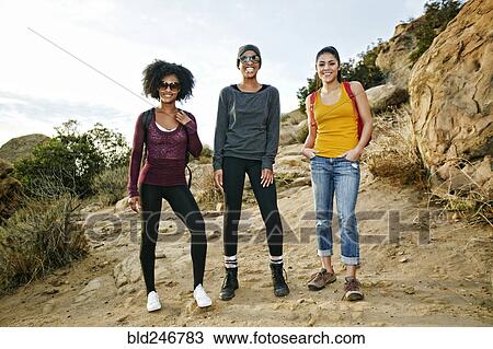 Stock Image - Portrait of smiling women hiking. Fotosearch