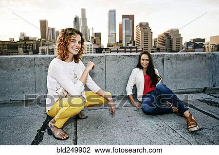 Portrait of smiling women on urban rooftop View Large Photo Image Stock Image - Portrait of smiling women on urban rooftop. Fotosearch
