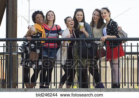 Portrait of smiling women posing behind railing View Large Photo Image Picture - Portrait of smiling women posing behind railing. Fotosearch