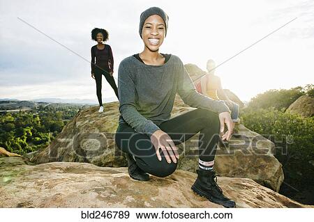 Stock Photo - Portrait of smiling women posing on rock formation. Fotosearch
