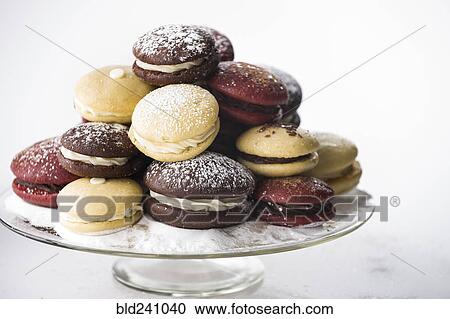 Stock Image - Powdered sugar on tray of cookies. Fotosearch