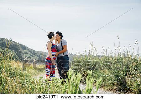 Pregnant lesbian couple kissing on path View Large Photo Image Stock Image - Pregnant lesbian couple kissing on path. Fotosearch