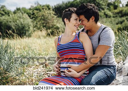 Pregnant lesbian couple rubbing noses outdoors View Large Photo Image Picture - Pregnant lesbian couple rubbing noses outdoors. Fotosearch