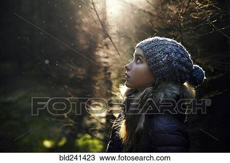 Stock Image - Profile of Caucasian teenage girl in forest. Fotosearch