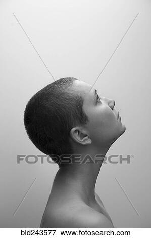 Stock Photo - Profile of Caucasian woman with shaved-head looking up. Fotosearch