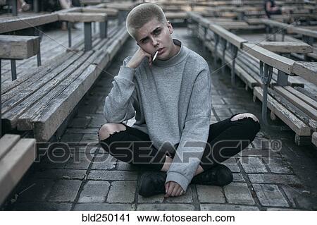 Punk Caucasian woman sitting on cobblestones smoking cigarette View Large Photo Image Stock Image - Punk Caucasian woman sitting on cobblestones smoking cigarette. Fotosearch