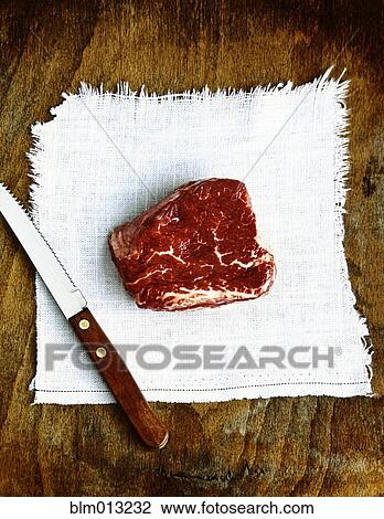 Stock Image - Raw beef and knife. Fotosearch