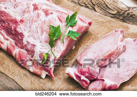 Picture - Raw meat and garnish on butcher paper. Fotosearch