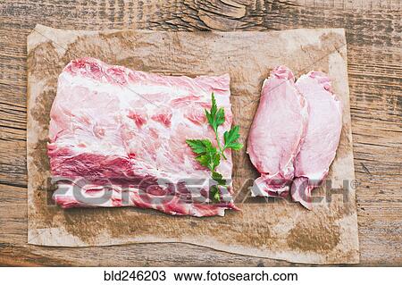 Stock Image - Raw meat and garnish on butcher paper. Fotosearch