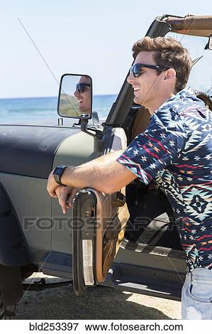 Reflection of Caucasian man in side-view mirror of car on beach View Large Photo Image Stock Photo - Reflection of Caucasian man in side-view mirror of car on beach. Fotosearch