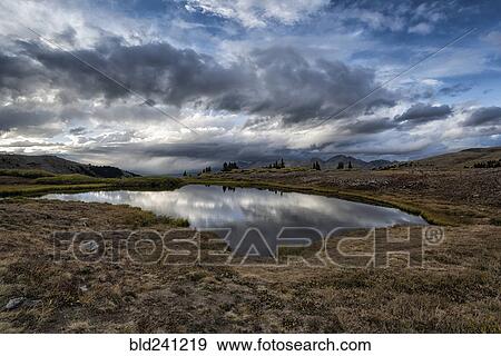 Stock Photo - Reflection of clouds in remote lake. Fotosearch