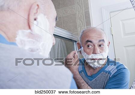 Reflection of Hispanic man shaving face in mirror View Large Photo Image Stock Photo - Reflection of Hispanic man shaving face in mirror. Fotosearch