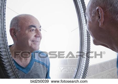 Reflection of smiling Hispanic man in bathroom mirror View Large Photo Image Stock Photo - Reflection of smiling Hispanic man in bathroom mirror. Fotosearch
