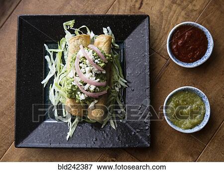 Stock Photo - Rolled chicken taco and salsa. Fotosearch