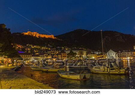 Stock Image - Scenic view of boats at waterfront at night. Fotosearch