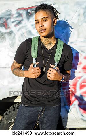 Stock Photo - Serious androgynous Mixed Race woman posing near truck. Fotosearch