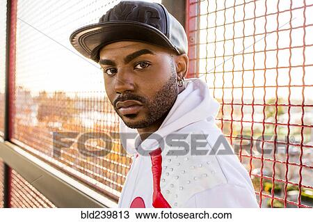 Serious Black man near fence View Large Photo Image Stock Image - Serious Black man near fence. Fotosearch