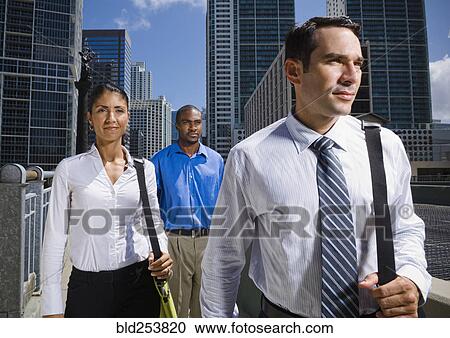Serious business people walking in city View Large Photo Image Stock Image - Serious business people walking in city. Fotosearch
