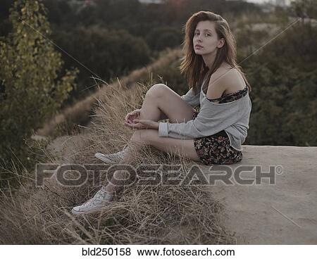 Serious Caucasian woman sitting on hill View Large Photo Image Stock Photo - Serious Caucasian woman sitting on hill. Fotosearch