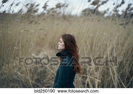 Serious Caucasian woman standing in field View Large Photo Image Stock Image - Serious Caucasian woman standing in field. Fotosearch