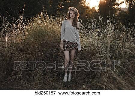 Serious Caucasian woman standing in field View Large Photo Image Stock Photo - Serious Caucasian woman standing in field. Fotosearch