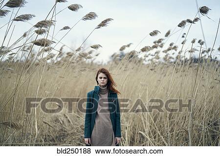 Serious Caucasian woman standing in field View Large Photo Image Stock Photo - Serious Caucasian woman standing in field. Fotosearch