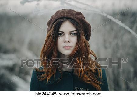Stock Photography - Serious Caucasian woman standing in field. Fotosearch