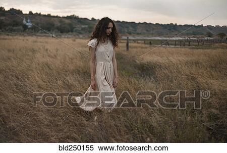 Serious Caucasian woman walking in field View Large Photo Image Stock Photography - Serious Caucasian woman walking in field. Fotosearch