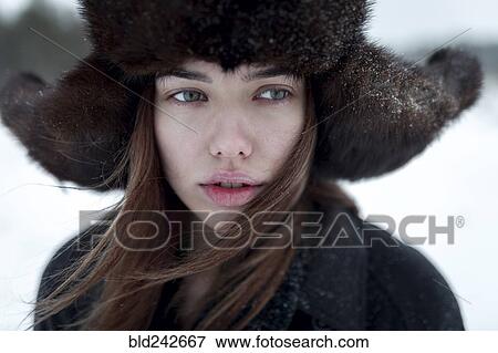Stock Photo - Serious Caucasian woman wearing fur hat and coat in winter. Fotosearch