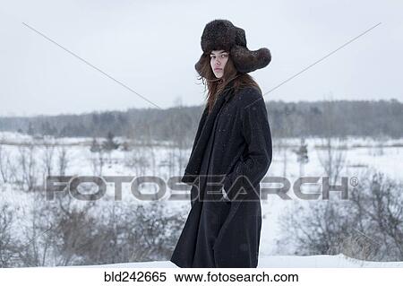 Stock Photography - Serious Caucasian woman wearing fur hat and coat in winter. Fotosearch