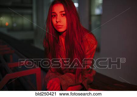 Stock Image - Serious Caucasian woman wearing jacket at night. Fotosearch