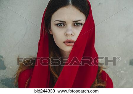 Stock Image - Serious Caucasian woman wearing red headscarf. Fotosearch