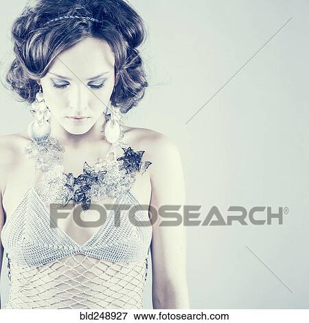Stock Photo - Serious Caucasian woman wearing sheer dress looking down. Fotosearch
