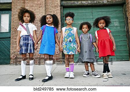 Stock Photography - Serious girls posing on city sidewalk. Fotosearch