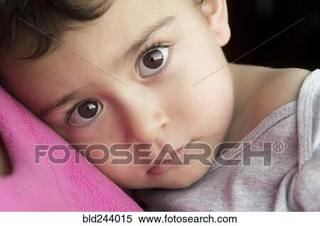 Serious Hispanic boy resting head on chest of mother View Large Photo Image Stock Photography - Serious Hispanic boy resting head on chest of mother. Fotosearch