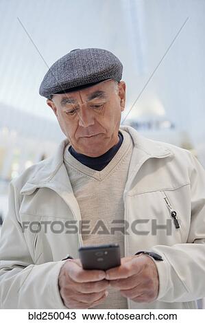 Serious Hispanic man texting on cell phone View Large Photo Image Stock Image - Serious Hispanic man texting on cell phone. Fotosearch