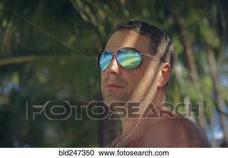 Stock Image - Serious man wearing sunglasses in summer. Fotosearch