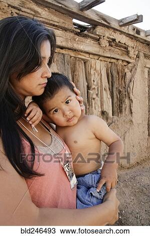 Stock Image - Serious mother holding son outdoors. Fotosearch