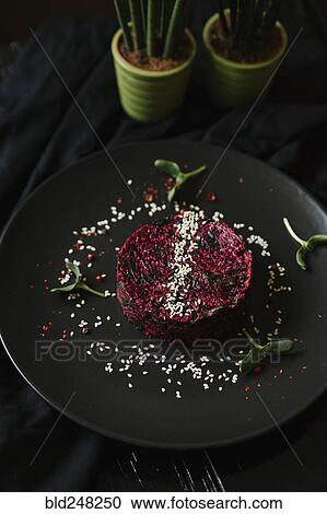 Stock Image - Sesame seeds and garnish on red food on plate. Fotosearch