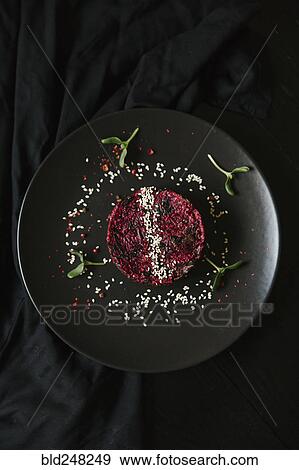 Stock Photo - Sesame seeds and garnish on red food on plate. Fotosearch