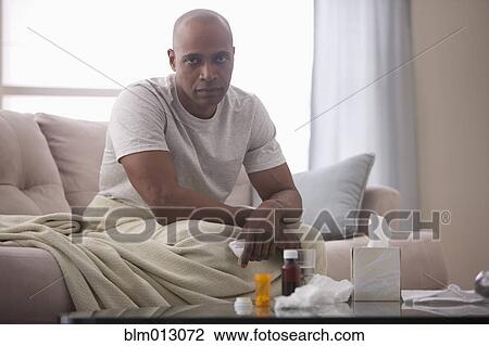 Sick Black man sitting on sofa View Large Photo Image Stock Image - Sick Black man sitting on sofa. Fotosearch