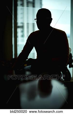 Silhouette of Hispanic man sitting at table View Large Photo Image Stock Image - Silhouette of Hispanic man sitting at table. Fotosearch