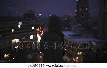 Silhouette of man on roof in city at night View Large Photo Image Picture - Silhouette of man on roof in city at night. Fotosearch