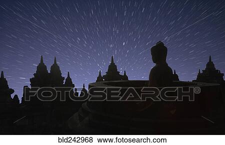 Stock Photo - "Silhouette of statue of Buddha at sunset, Borobudur, Java, Indonesia". Fotosearch