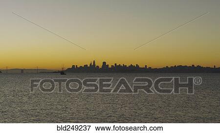 Stock Photo - Silhouette of urban waterfront skyline at sunset. Fotosearch