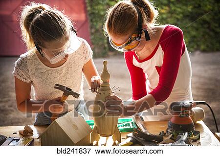 Sisters building birdhouse in garage View Large Photo Image Stock Photo - Sisters building birdhouse in garage. Fotosearch