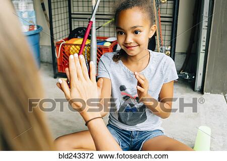 Stock Image - Sisters playing hand clapping game. Fotosearch